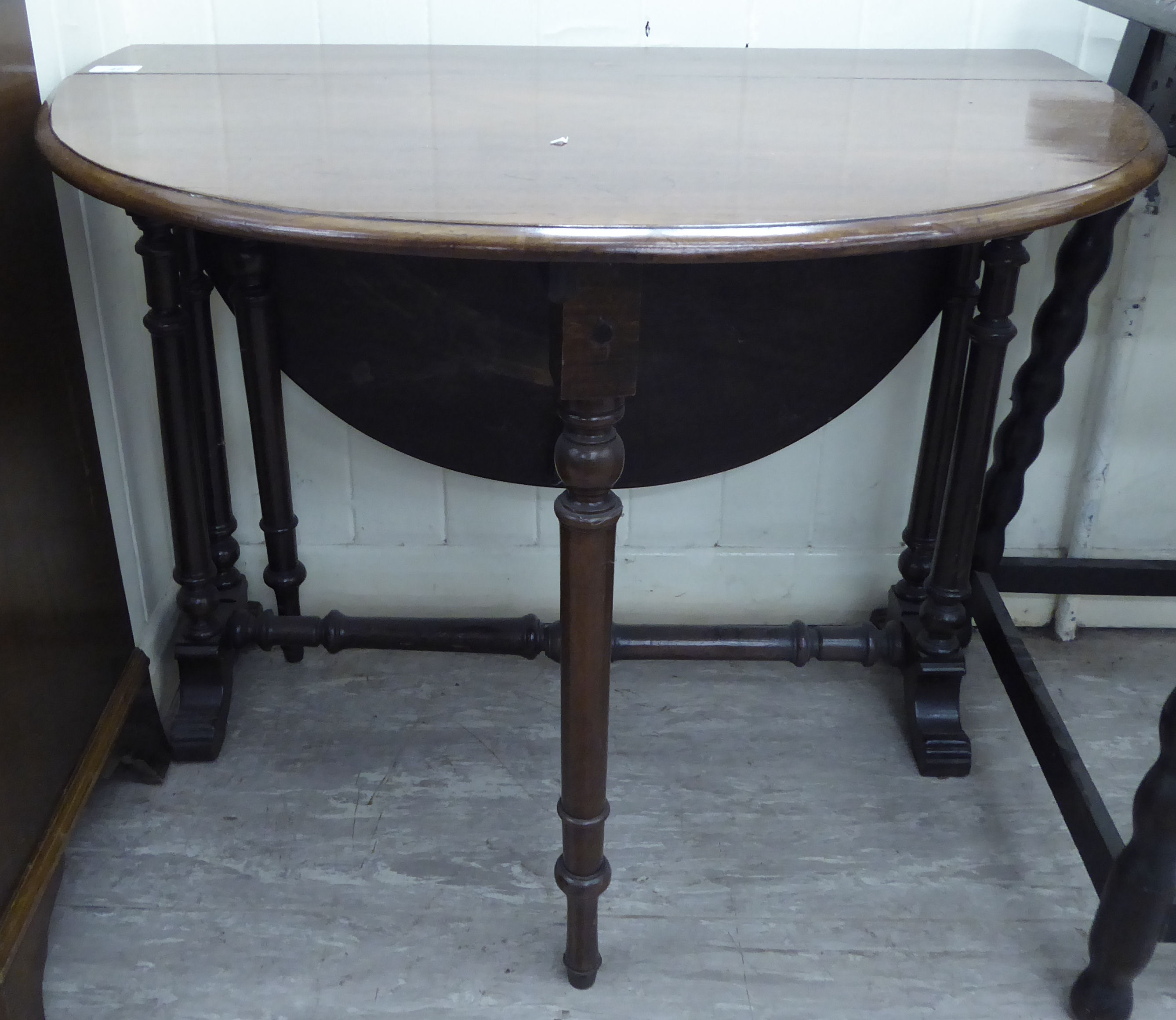 A late Victorian mahogany Sutherland table, the oval top raised on ring turned,