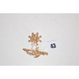 Two seed pearl brooches, one of snowflake form, the other of floral design, stamped '15ct.'.