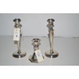 A pair of silver candlesticks with urn-shaped sconces and tapering stems;