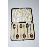 A set of six silver teaspoons with light blue enamel finials, in fitted case.