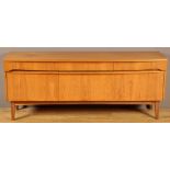 Remploy: a teak sideboard, fitted three drawers above a central fall-flap flanked by cupboard doors,