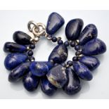 Hoorieh Coish: a lapis lazuli bangle, in baroque form beads with silver clasp, 17cms long.