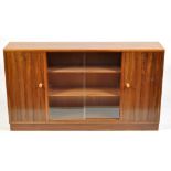 A 1980's teak display side cabinet, the glazed central sliding doors flanked by solid wooden doors,