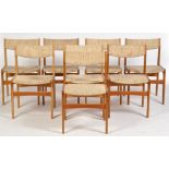 A set of eight 1980's teak dining chairs, the backs and seats covered in woollen material,