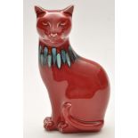 Poole: figure of a cat, red glaze with blue and orange glaze to neck, stamped to base, 18cms (7in.