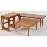 A nest of teak coffee tables, the swivel turnover top above two smaller pull-out side tables,