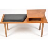 A 1970's teak telephone table, with cushioned seat, raised on turned tapering legs,