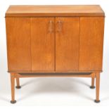 A 1980's teak drinks cabinet, the hinged doors enclosing mirror back,