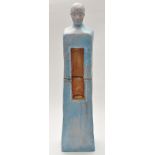 A surreal figure of a man, blue glaze, gold painted niche to torso, in two sections,