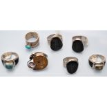 A fossil set ring; together with three other fossil rings; two turquoise set rings;