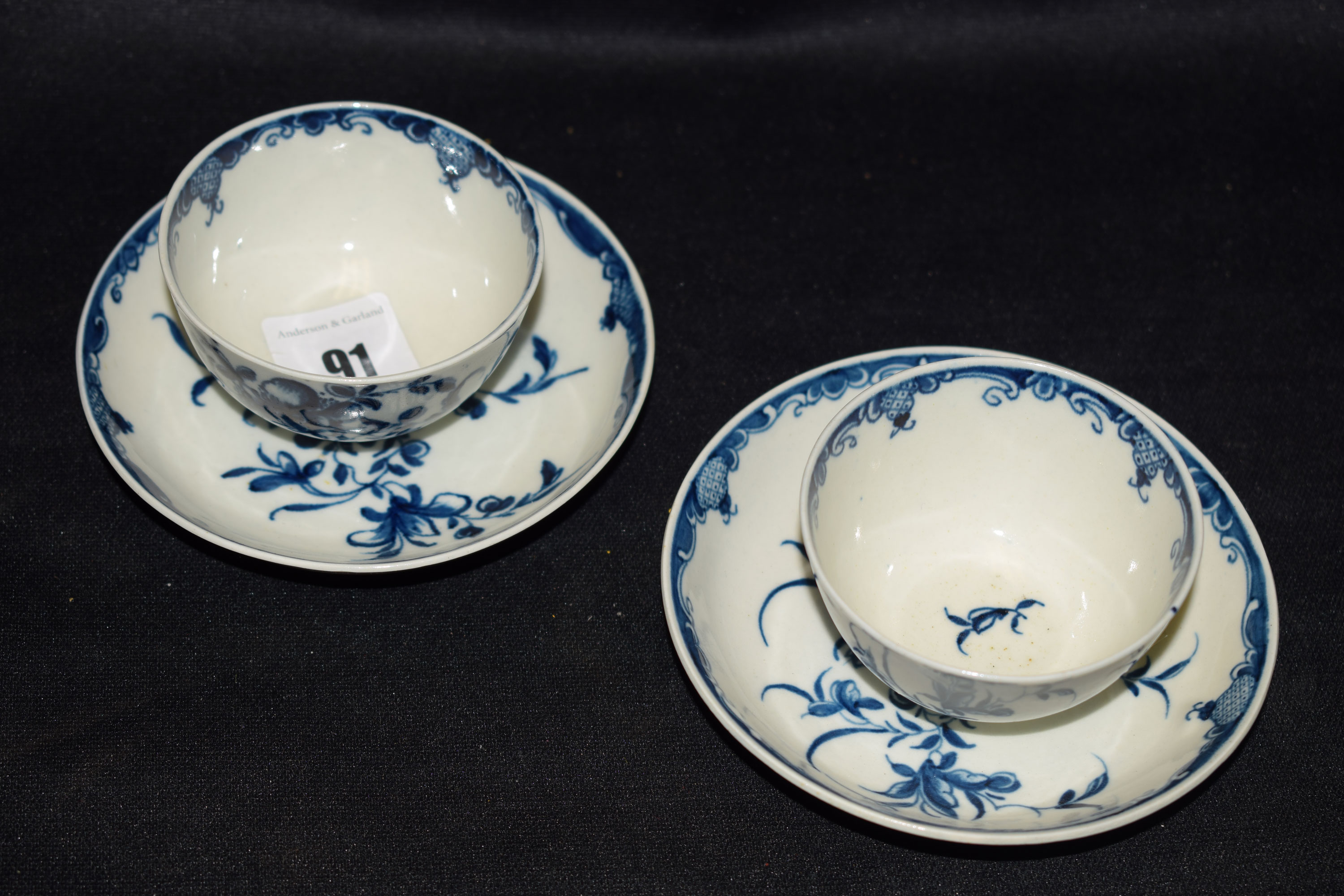 A pair of first period Worcester tea bowls and saucers, floral spray decoration, marks to base.