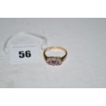 A ruby and diamond ring, centred by three graduated rubies on 9ct. yellow gold shank, ring size P.