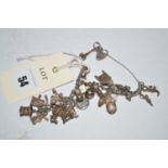 A silver charm bracelet, the charms include: Scott memorial, windmill, tractor, pram,