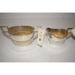 A silver two-handled sugar bowl and matching cream jug, of half-fluted form, by Walker & Hall,