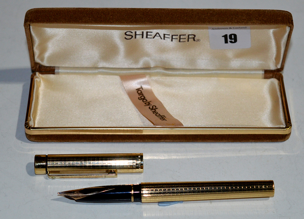 A Sheaffer Targa fountain pen, in square cut gold coloured electroplate case, fitted 14ct.