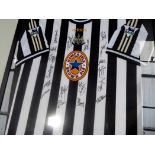 A Newcastle United replica football shirt, signed by the squad, c.1997-98 season, framed.