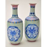 Small pair of Chinese green ground vases, ovoid bodies with reserve panels decorated in blue enamel,