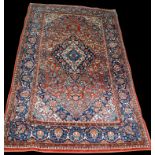 A Kashan rug, full floral decoration on red ground, 217 x 135cms (85 1/2 x 53in.).