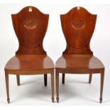 A near pair of early 19th Century mahogany hall chairs,
