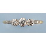 A diamond ring, the three brilliant cut graduated diamonds flanked by diamond set chenier shoulders,