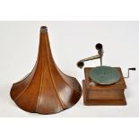 An early 20th Century gramophone, the ribbed and flared oak horn on metal fitting,