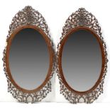 A very near pair of George III mahogany pierced fretwork mirrors,