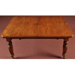 A Victorian oak extending dining table, the top with canted corners,