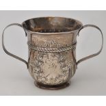 A white metal two-handled porringer, with fluted and embossed decoration, loop handles,