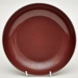 Chinese copper-red glaze saucer dish, covered evenly upon the interior and exterior, everted rim,