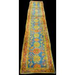 A Ushak runner, with medallions on blue ground, 640 x 113cms (252 x 44 1/2in.).