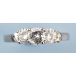 A three stone diamond ring, the brilliant cut diamonds in high pierced setting,