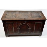 An early 19th Century oak coffer, the plain panel top above arched central panel front,