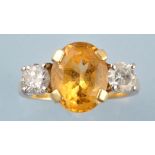 A citrine and diamond ring, the oval facet cut citrine flanked by brilliant cut diamonds,