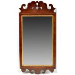 A George III style mahogany and parcel gilt wall mirror, with pierced and scrolling design,