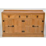 Malcolm "Foxman" Pipes: an adzed oak sideboard, fitted three drawers above panel doors,