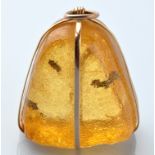 A 19th Century insect inclusion amber pendant, the polished amber dome with three ant inclusions,