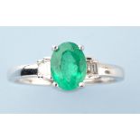 An emerald and diamond ring, the oval facet cut emerald four claw set,