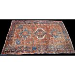 A Heriz rug, with triple geometric medallion on leaf decorated ground, 186 x 132cms (73 x 52in.).