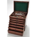 An early 20th Century mahogany dentist's cabinet, the hinged top fitted brass handle,