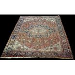 A Heriz carpet, with bold geometric floral design, 350 x 283cms (135 1/2 x 111 1/2in.).
