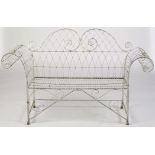 A late Victorian scrolling wirework and white painted galvanised cast-iron garden chair, 62in. wide.