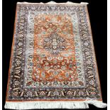 A Persian silk rug, with floral decoration and central foliate medallion,