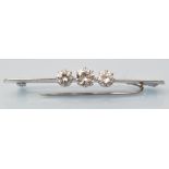 A three stone diamond bar brooch, the brilliant cut diamonds weighing a total of approximately 1.