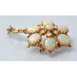 An opal, ruby and diamond brooch/pendant, of wreath form, mounted in yellow metal, 2.5cms wide.