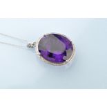 An amethyst and diamond cluster pendant, the oval facet cut amethyst measuring 21 x 17.