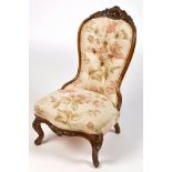 A Victorian walnut carved nursing chair,