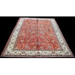 A Tabriz carpet, with scrolling floral design on red ground,