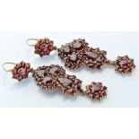 A pair of Victorian garnet drop earrings, each set with pear, circular and rose-cut garnets,