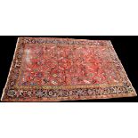 A Heriz carpet, with geometric flower and leaf design on red ground, 321 x 227cms (126 x 89in.).