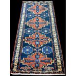 A Hamadan runner, with red medallions on blue ground, 300 x 102cms (118 x 40in.).